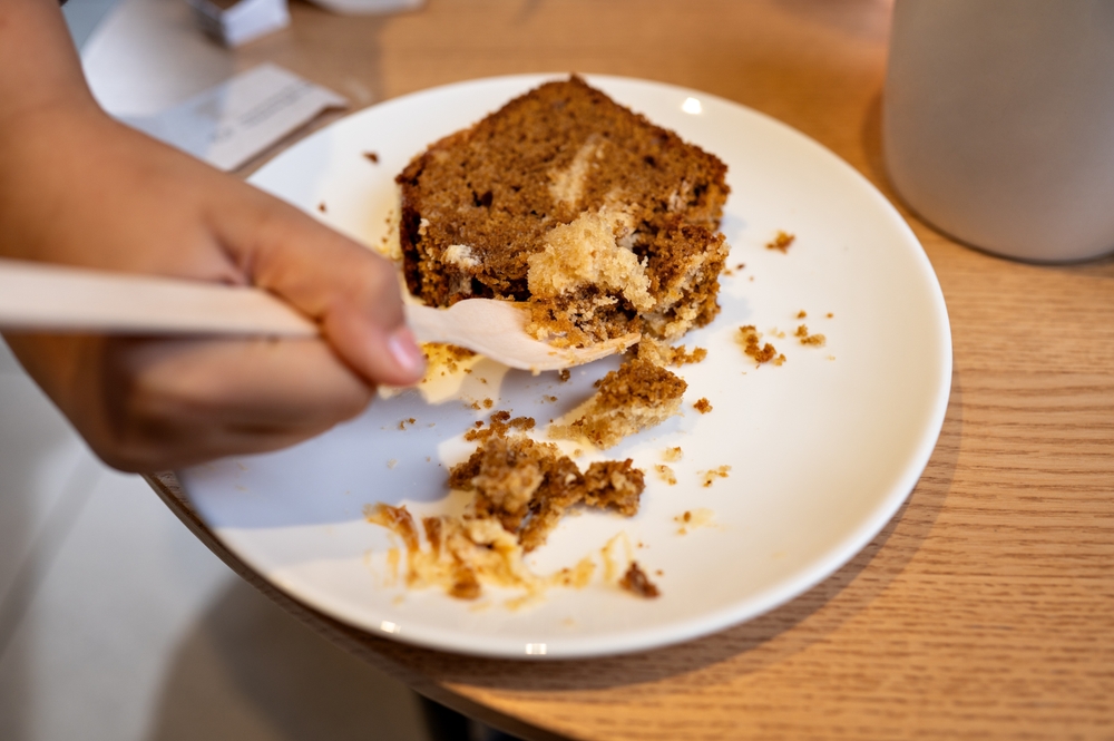 half eaten,piece,of,cake,on,white,plate,in,cafe.